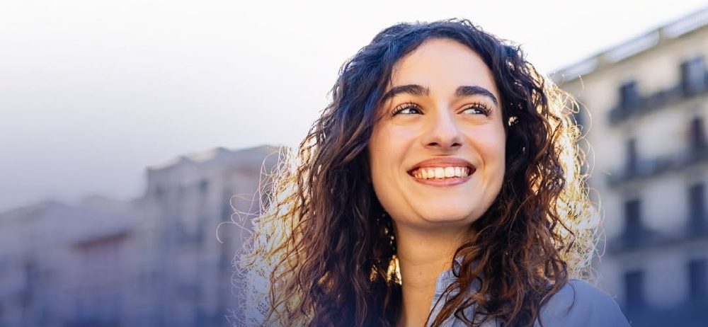 Mujer sonriendo con el celular en la mano
